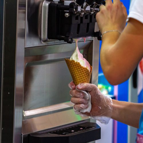 Preparation of creamy fruit ice cream from ice cream machine in shopping mall