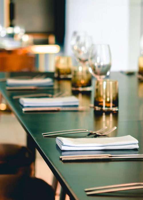 Empty glasses, plate, fork, knife on the table served for dinner in the modern restaurant